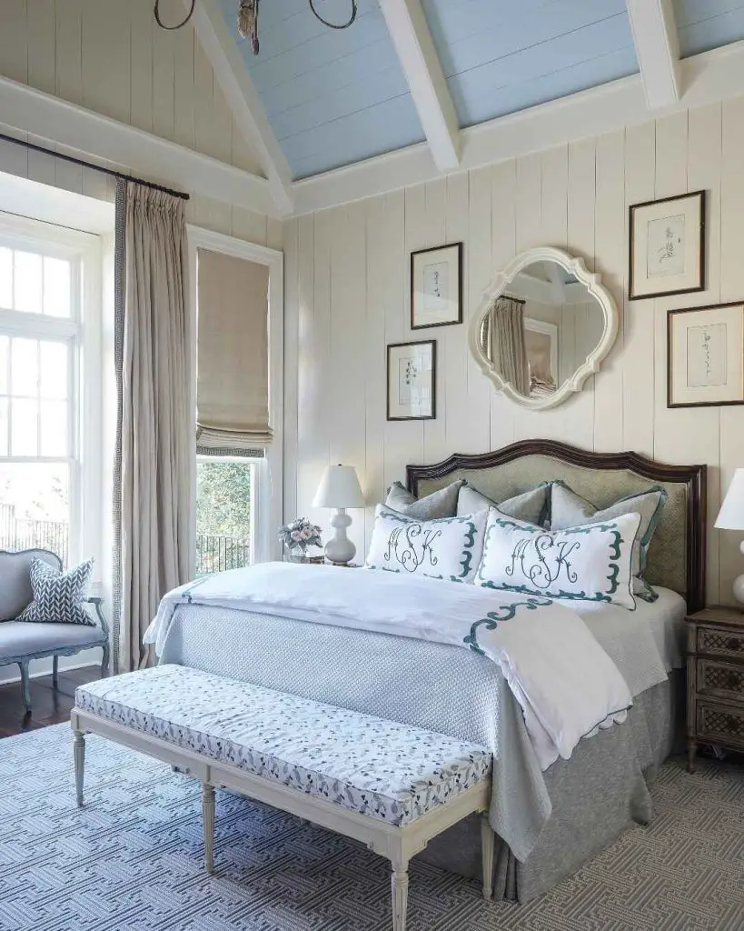 White bedroom with vaulted ceiling and monogrammed bedding