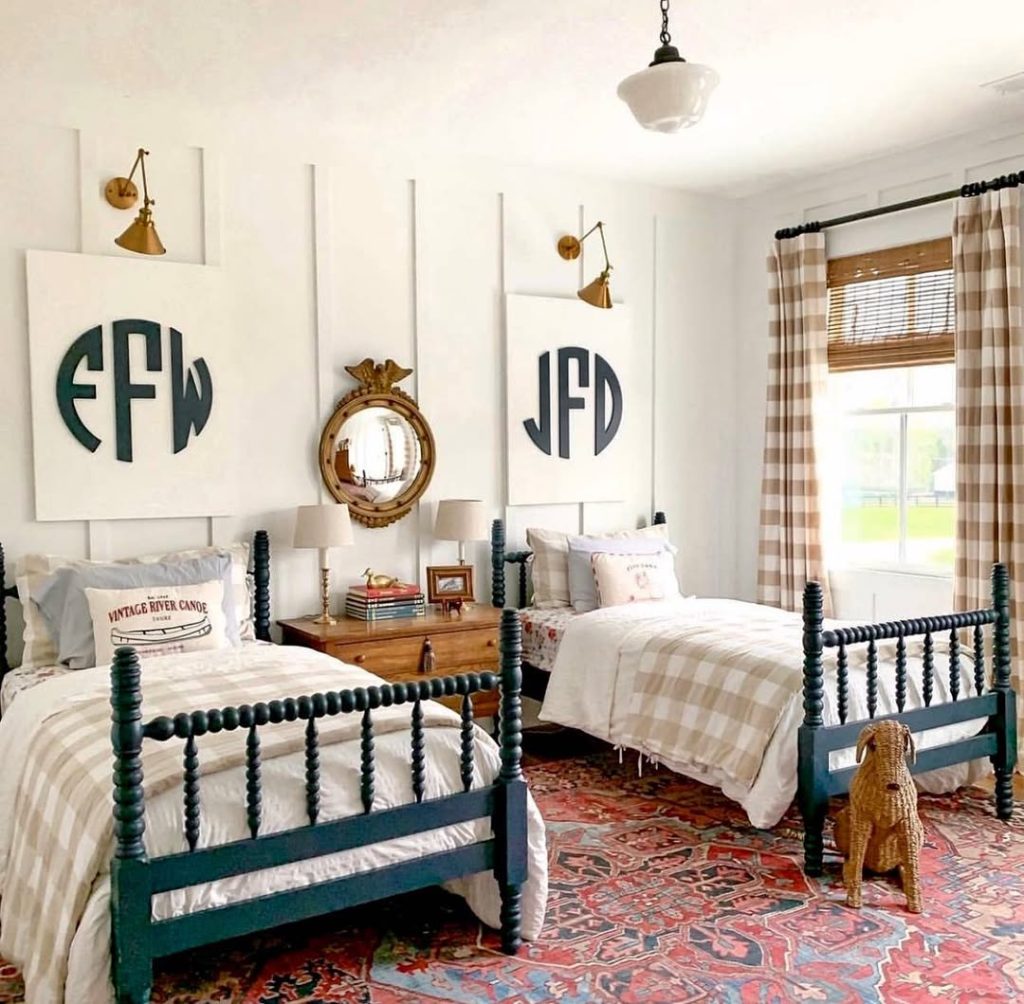 Twin bedroom with monogram art green beds and vintage rug