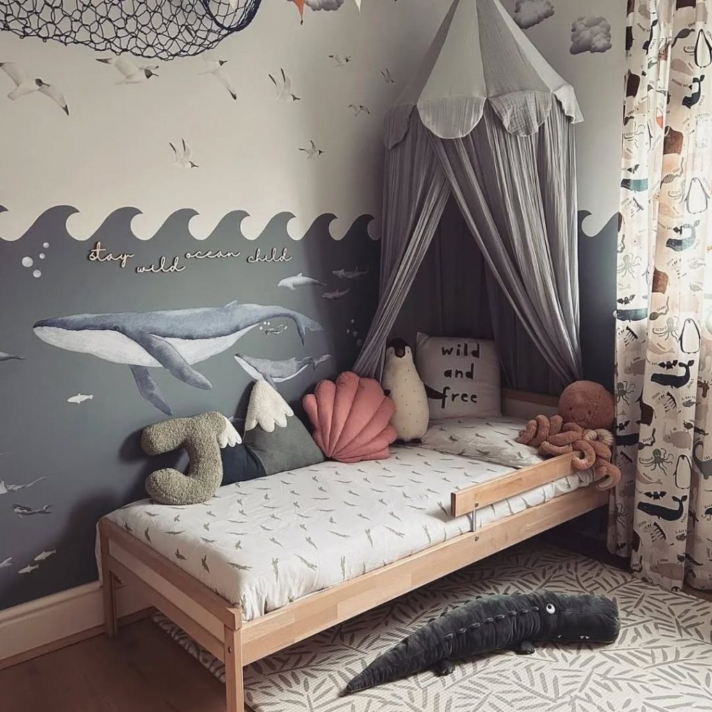Kids bedroom with whale mural canopy bed and ocean themed accessories