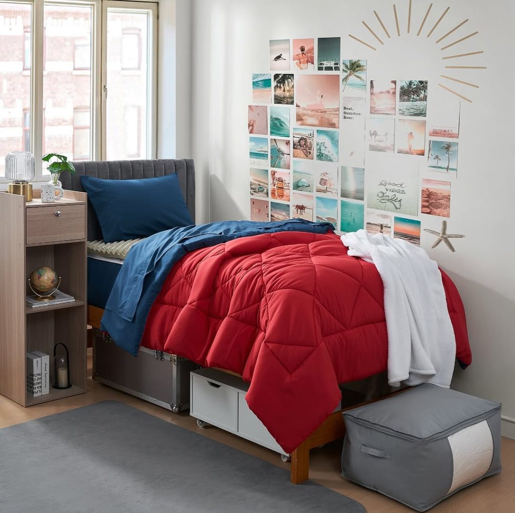 Red comforter with blue sheets and beach themed photo collage wall