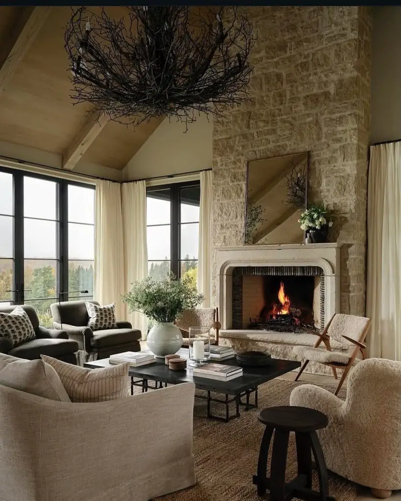 Living room with stone fireplace branch chandelier and cream furniture