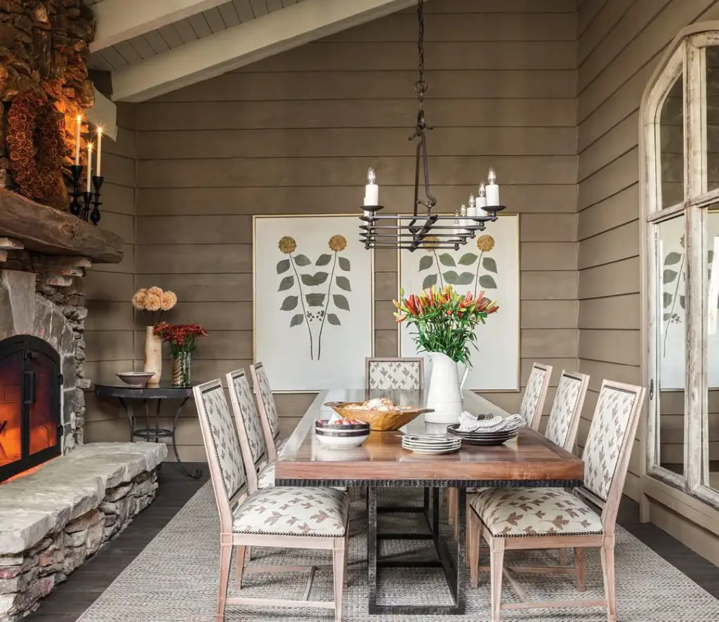 Rustic dining room with stone fireplace wooden table and floral centerpiece