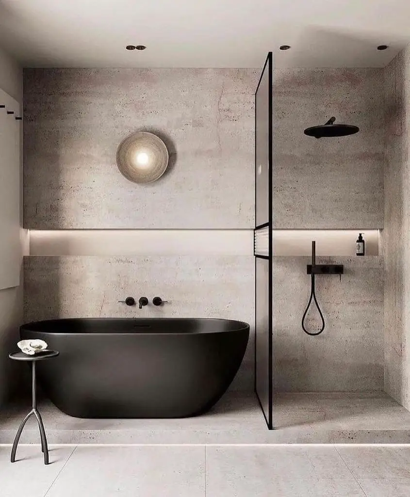 Modern bathroom with black freestanding tub and concrete walls with ambient lighting