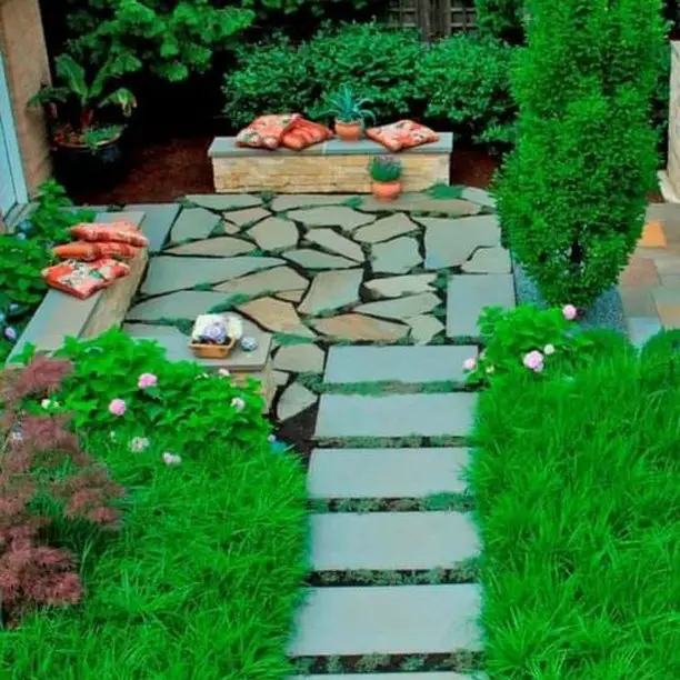 Curved concrete bench with fire bowl surrounded by large ferns
