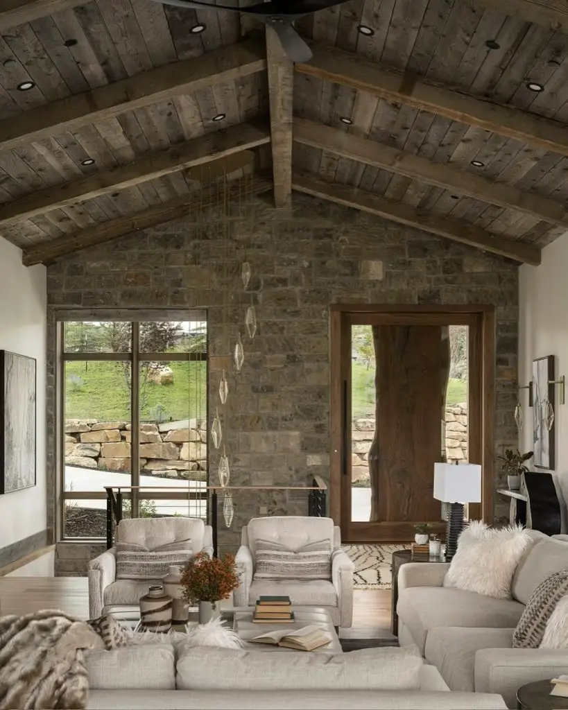 Lodge style living room with antler chandelier stone fireplace and neutral furniture
