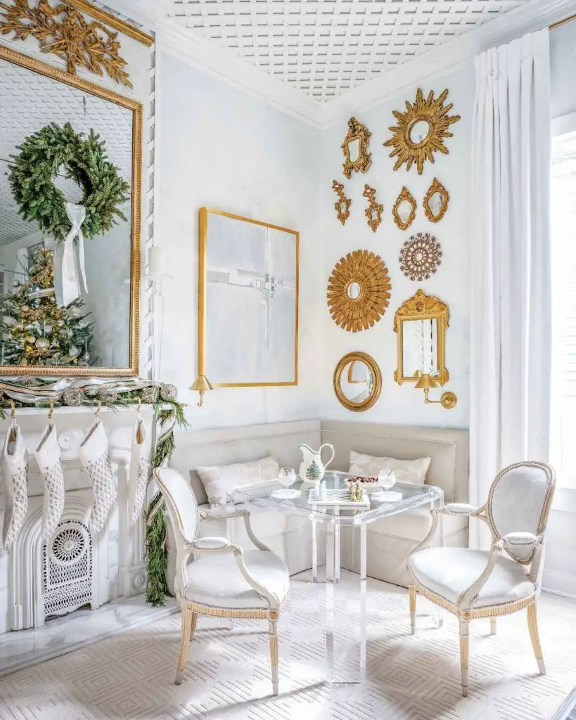  White living room with gold mirrors Christmas decorations and marble fireplace