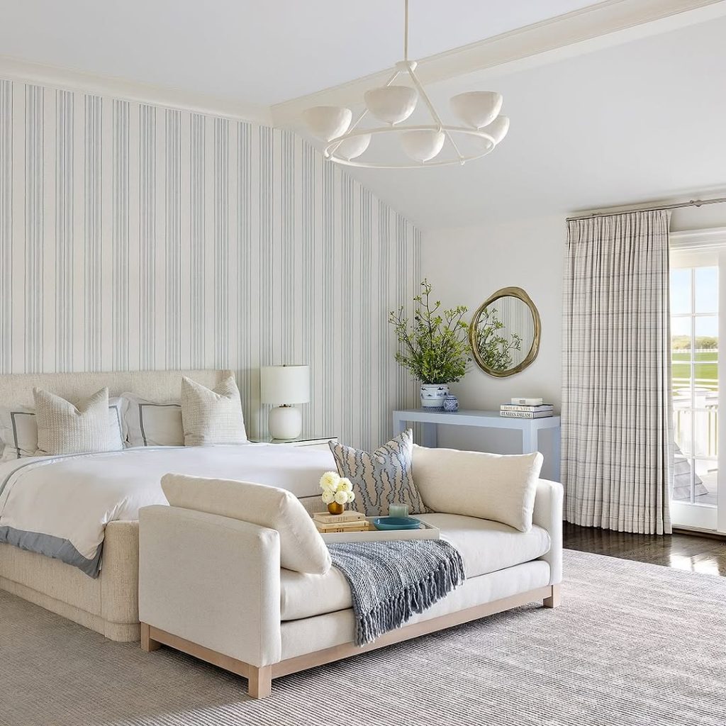 Bedroom with green sailboat wallpaper wooden bed and white shutters