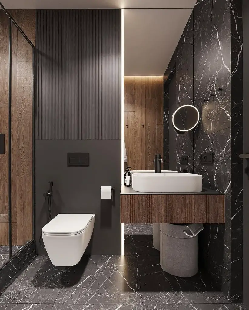 Modern bathroom with black marble walls floating wood vanity and LED mirror