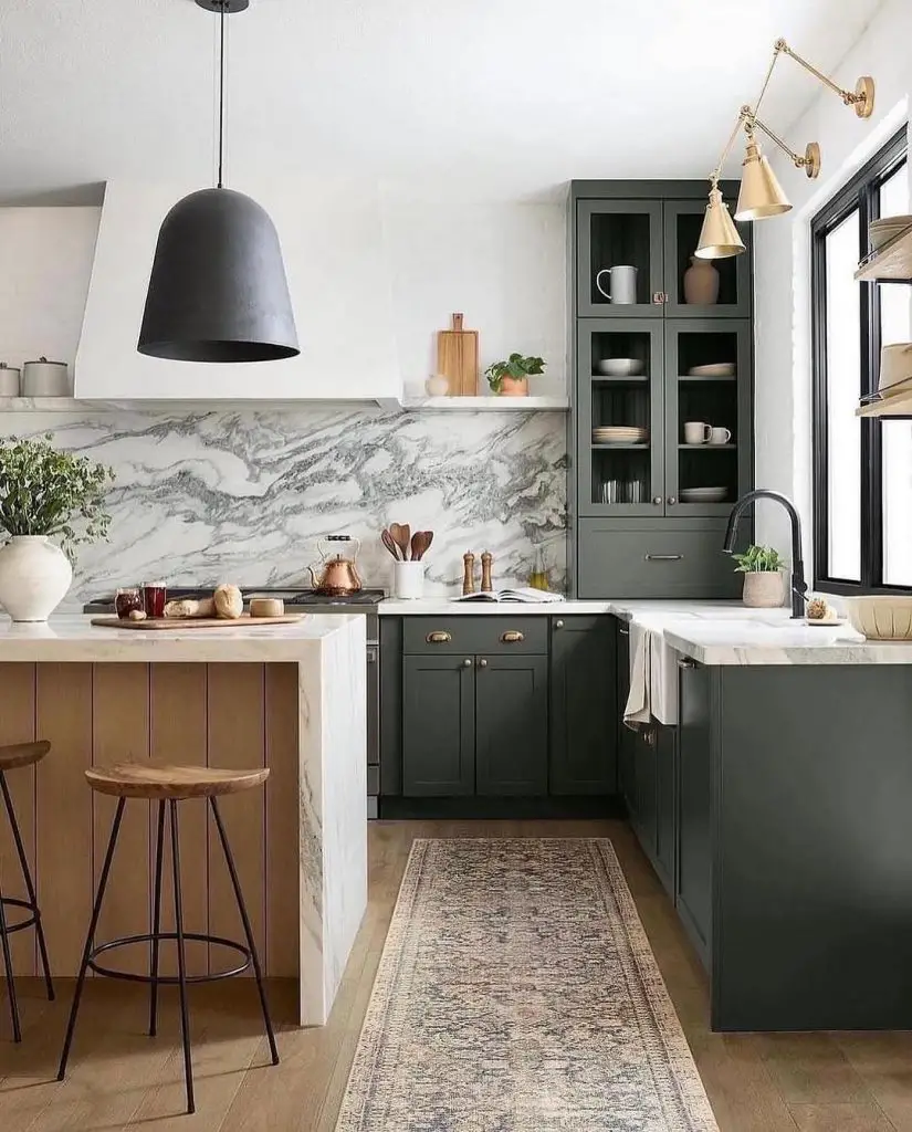 Modern sage kitchen featuring marble backsplash and black pendant light
