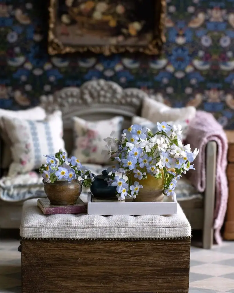 Blue flowers in pottery on ottoman with floral sofa background