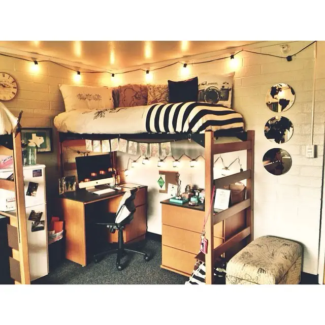 Modern loft bed setup with string lights desk underneath and black white decor