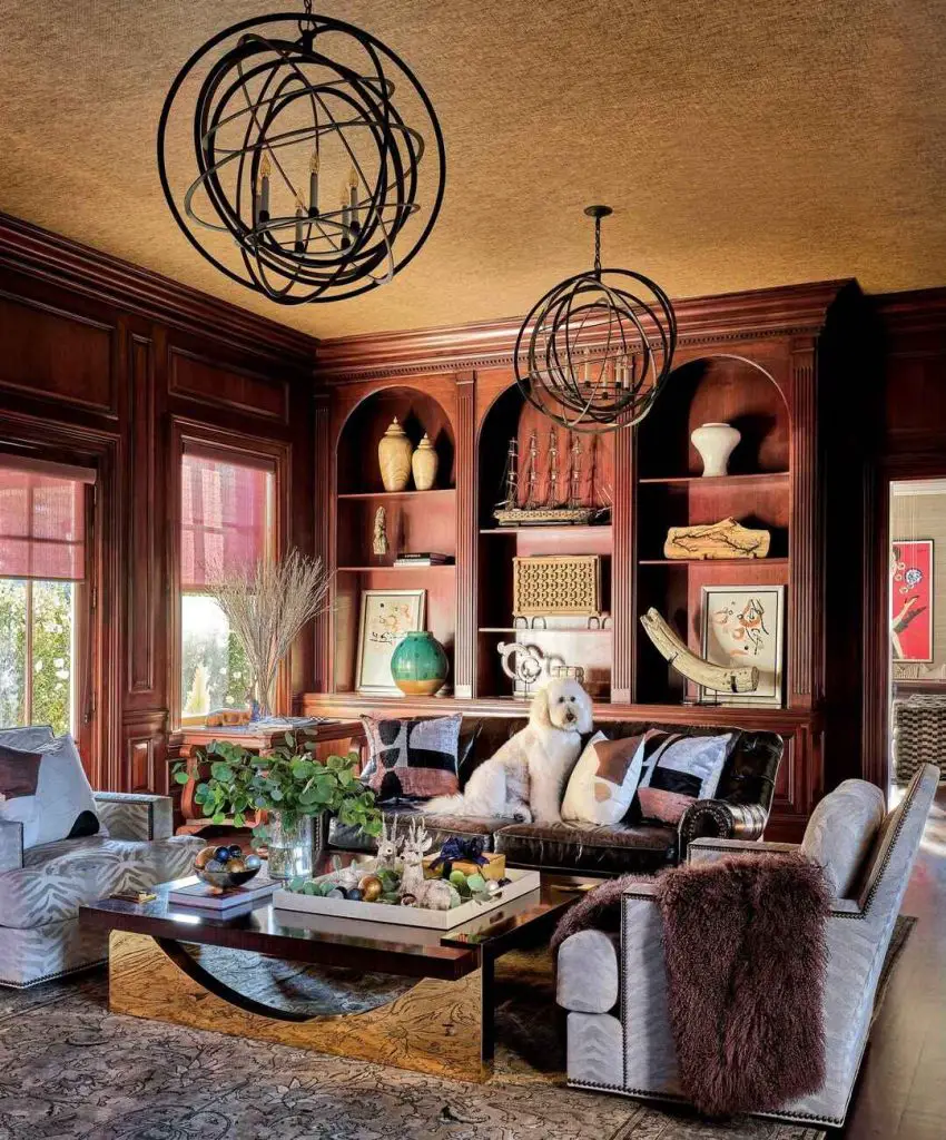 Wood paneled library with leather sofa and sphere chandeliers