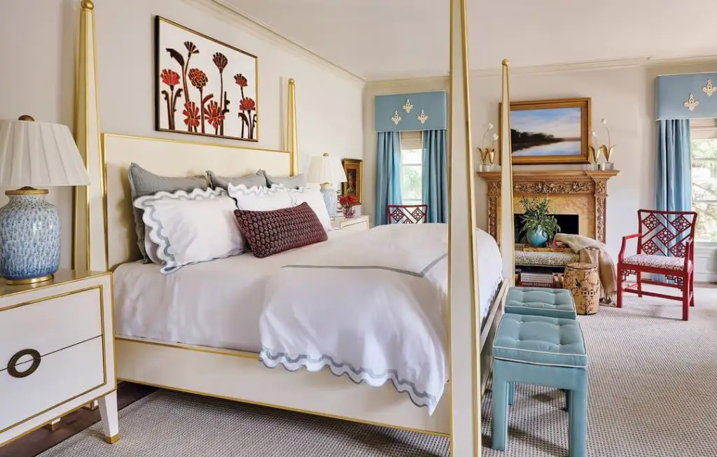 White bedroom with gold bed posts and blue accent pieces