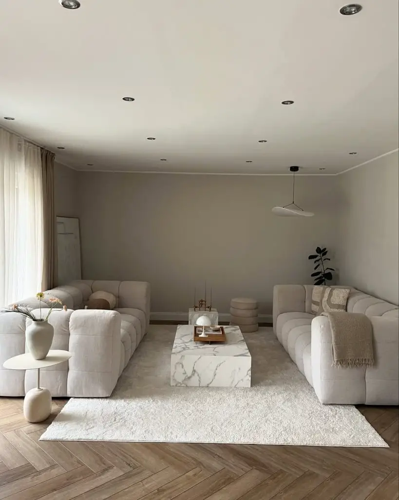 Minimalist white living room with symmetrical sofas and marble table