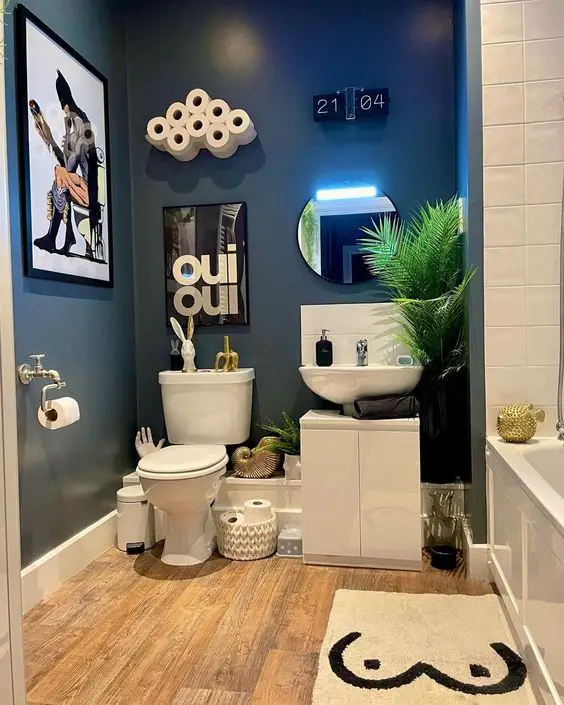 Navy bathroom with cloud toilet paper holder wood floors and modern art