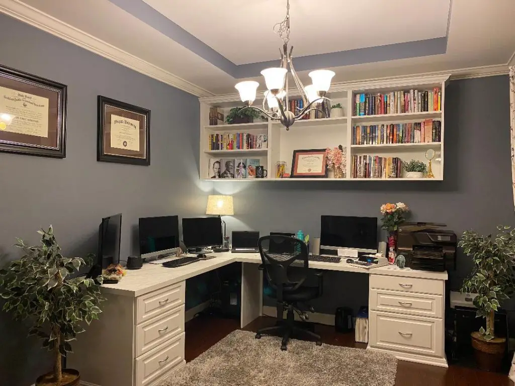 Gray cabinet office with large windows and wooden desk