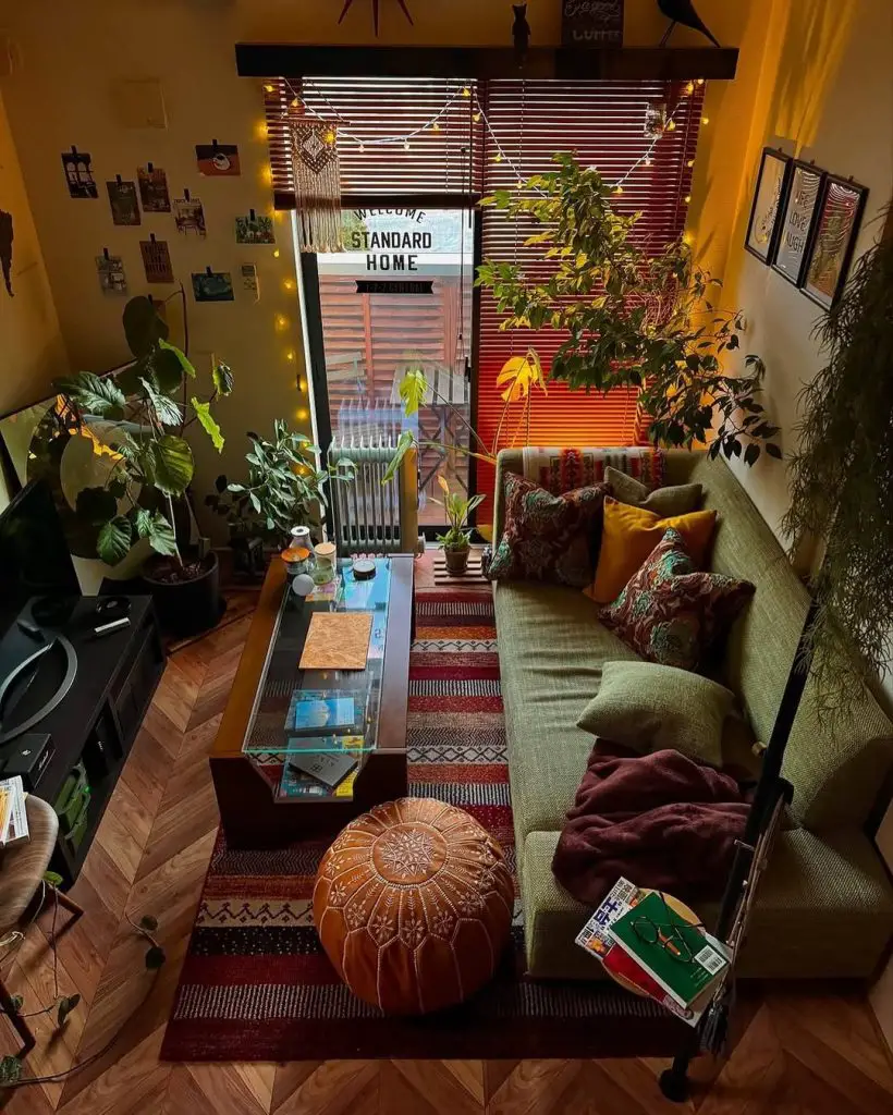 Small living room with green couch plants and warm lighting
