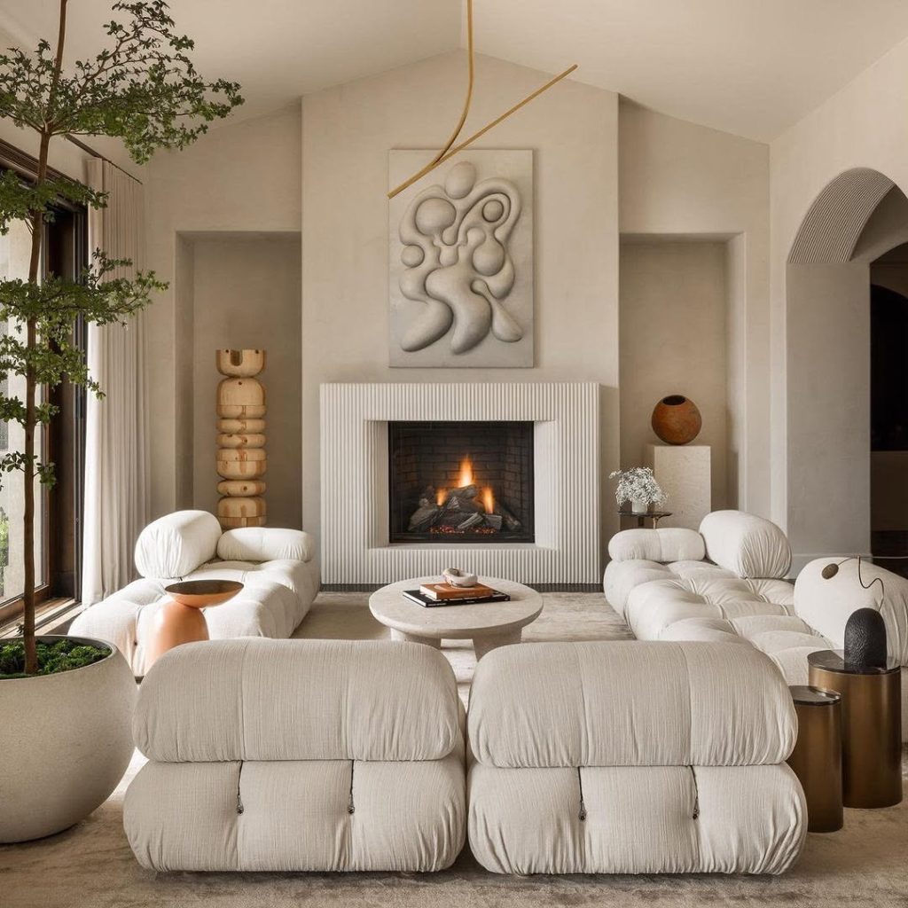 Modern white living room with sculptural furniture and ribbed fireplace