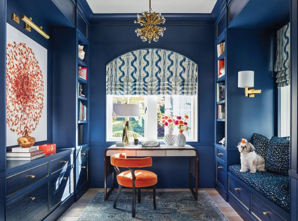 Blue home office with orange chair and built in storage