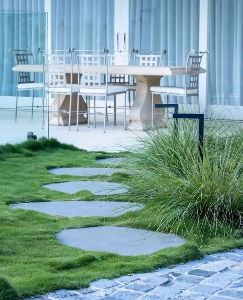 Modern stone path leading to white outdoor dining furniture