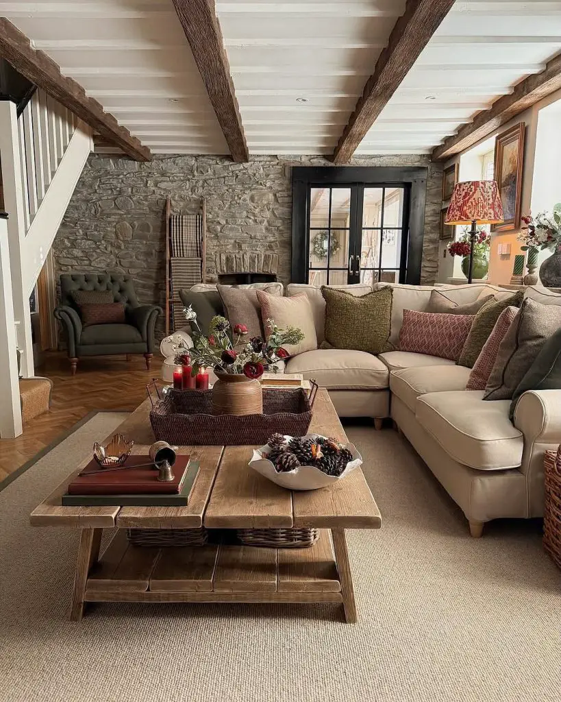 Cozy living room with stone walls wooden beams and floral centerpiece