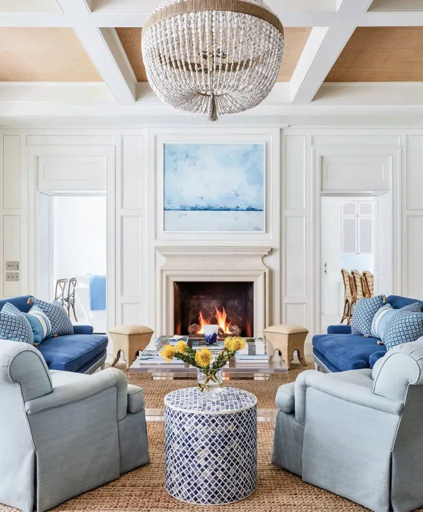 White living room with blue sofas and crystal chandelier