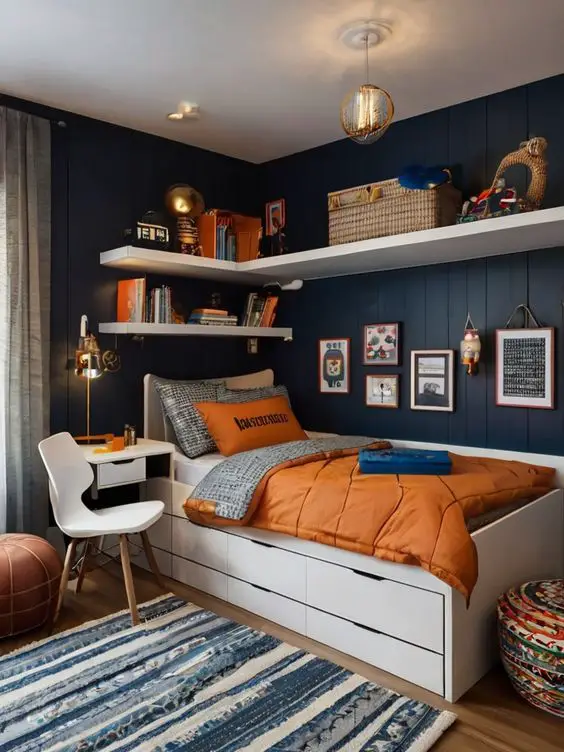 Navy blue bedroom with orange bedding white storage bed and striped rug