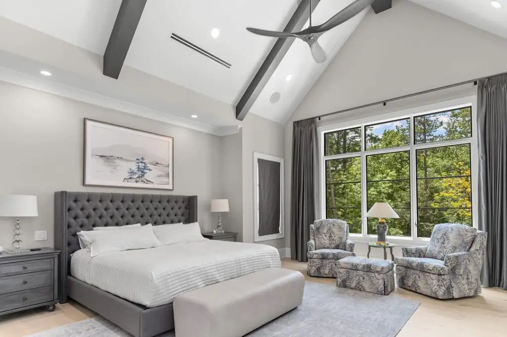 Elegant living room with high ceiling stone fireplace and matching cream sofas