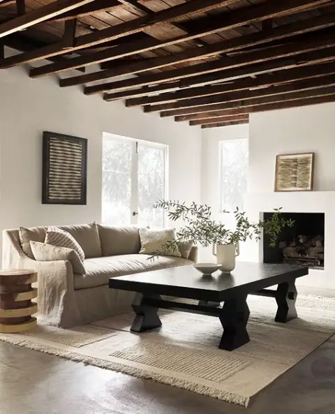 Minimalist living room with exposed ceiling beams and beige linen sofa