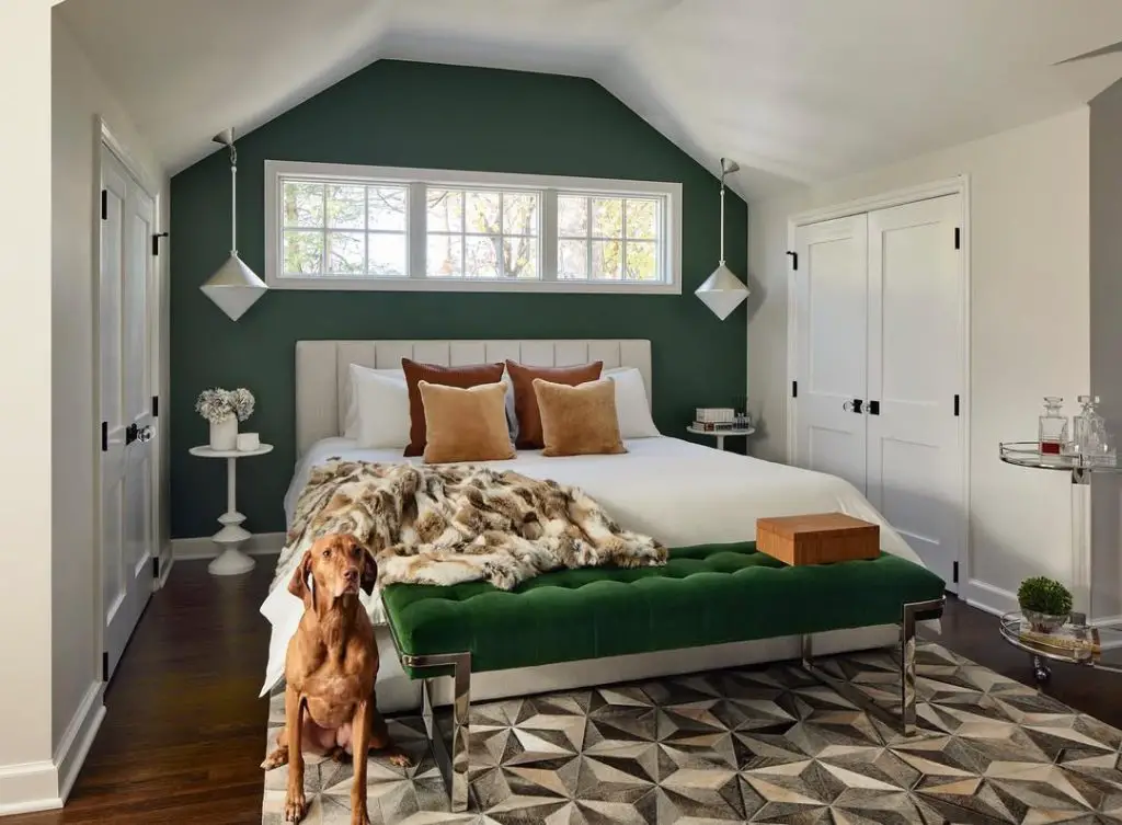 Light green bedroom with bay windows white headboard and plants