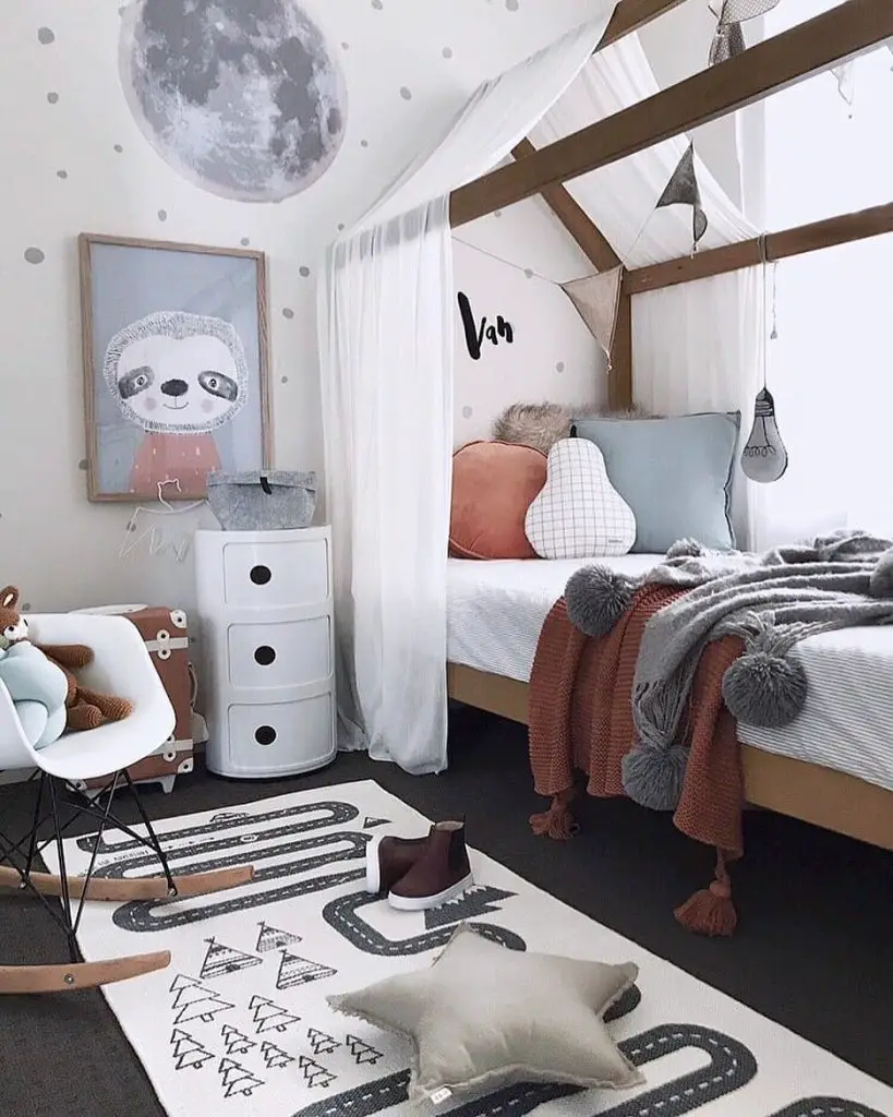 Kids bedroom with moon decal canopy bed and sloth artwork featuring modern storage