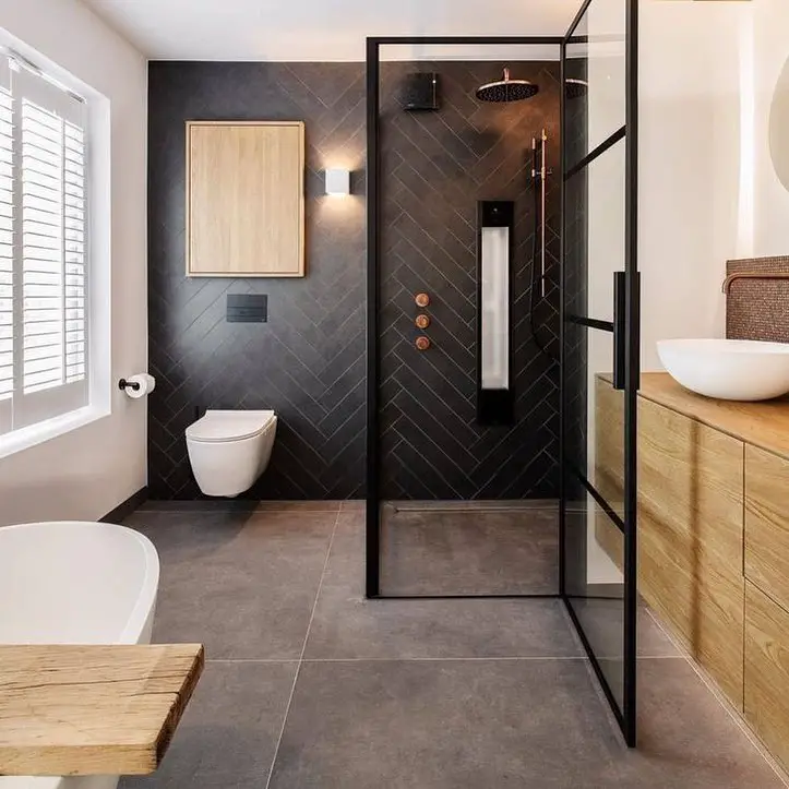Modern dark bathroom with glass shower white fixtures and wooden accents