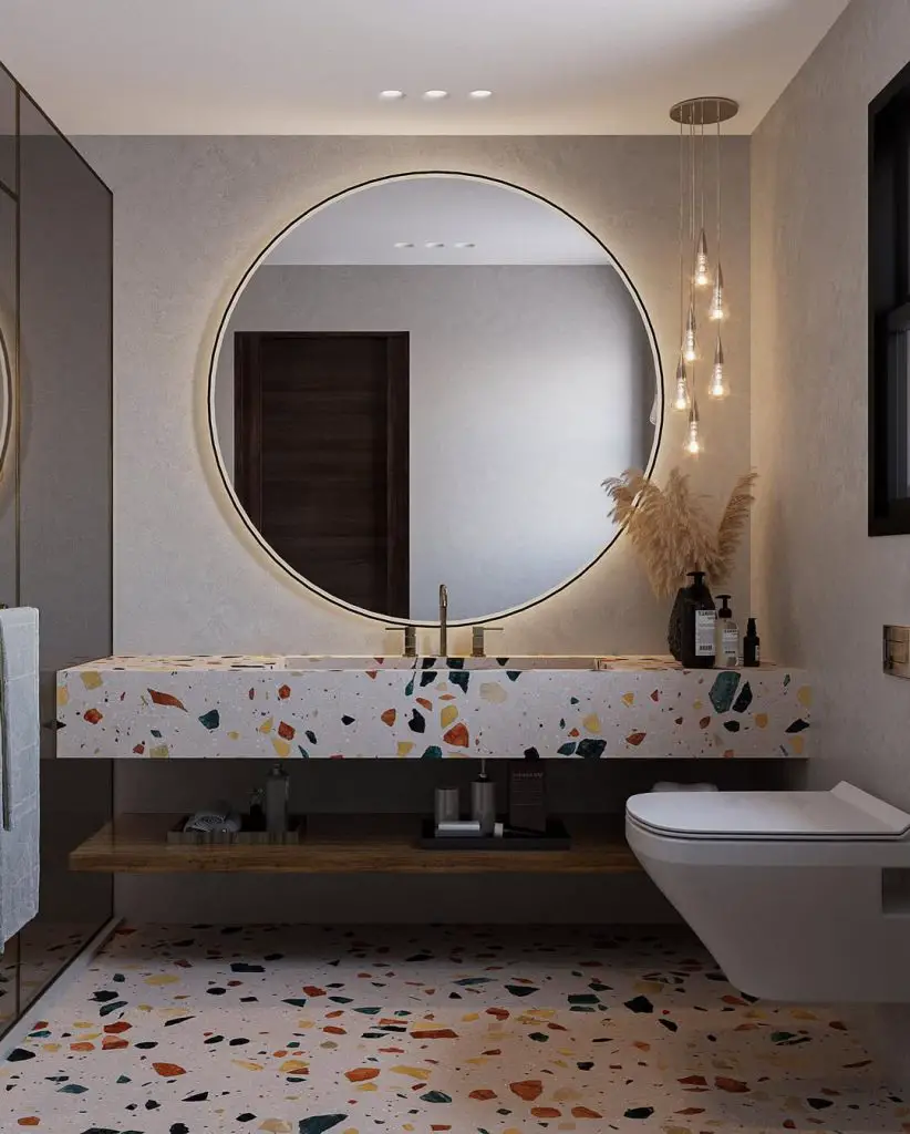 Modern bathroom with colorful terrazzo surfaces and round mirror