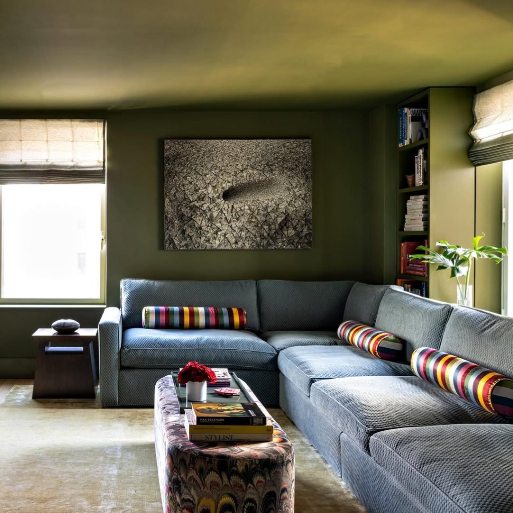 Living room with dark walls white sectional and geometric pattern rug