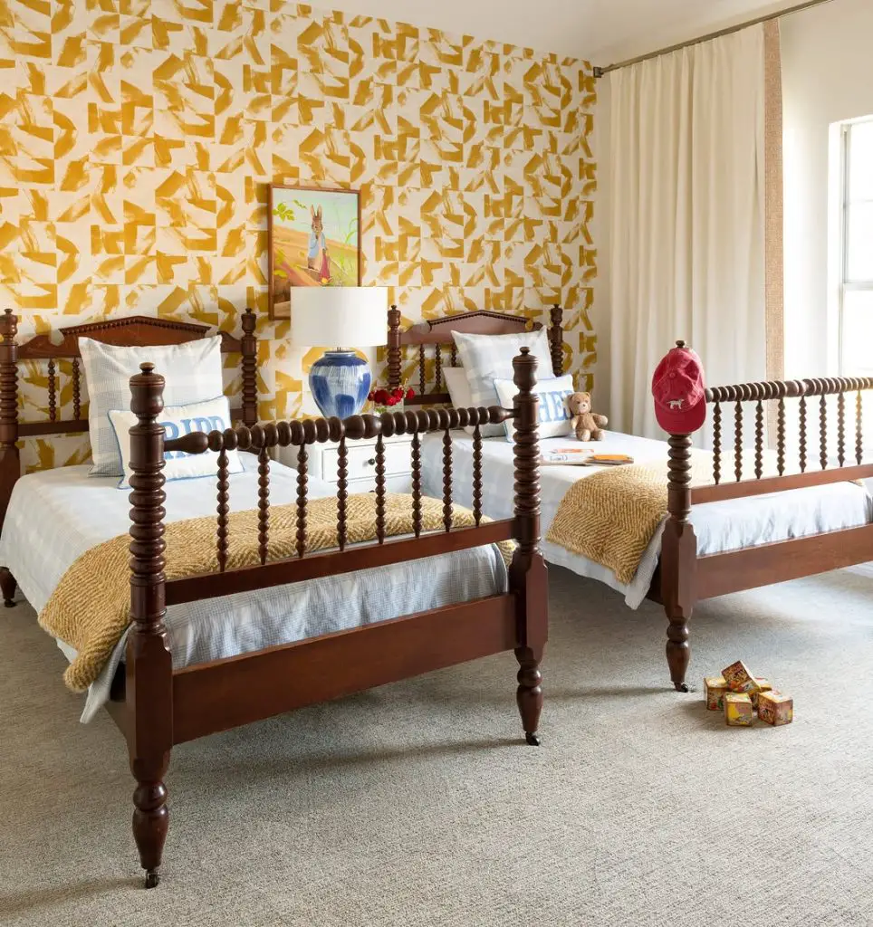 Twin bedroom with yellow geometric wallpaper and spindle beds