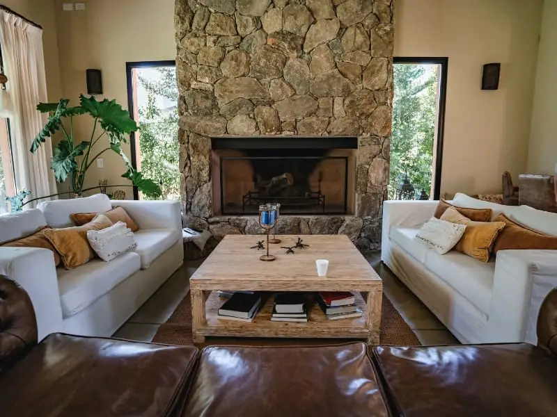 Rustic stone fireplace with modern sofas