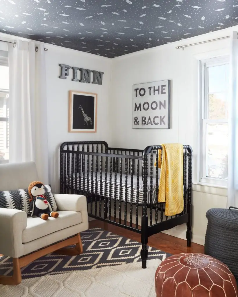 Modern nursery with constellation ceiling and black spindle crib