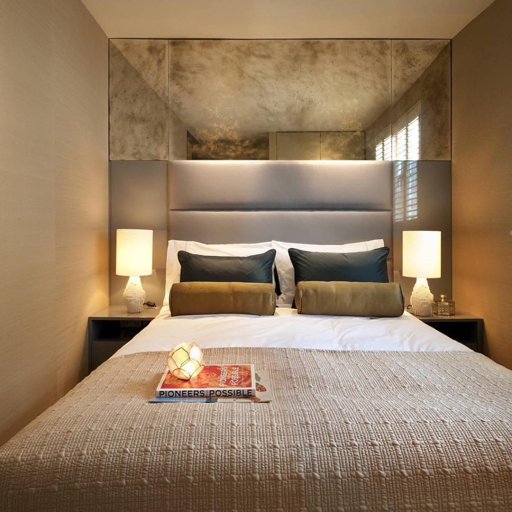 Modern bedroom with mirrored ceiling panels custom headboard and ambient lighting