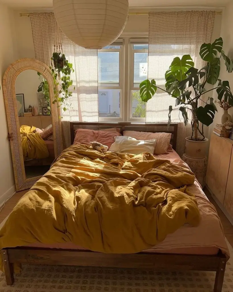 Bedroom with yellow bedding large mirror and gingham curtains