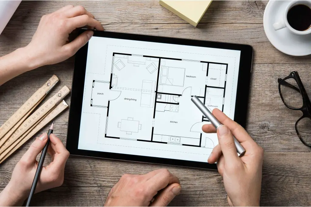 Hands working on digital floor plan on tablet