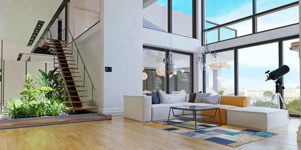 Contemporary open living room with glass walls and staircase.